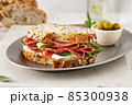 Sandwich with salami sausage and cucumber on marble background. 85300938