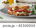 Sandwich with salami sausage and cucumber on marble background. 85300939