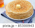 Crepes, thin pancakes with honey and butter on a white plate. Close up. 85300943