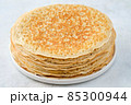 Crepes, thin pancakes with honey and butter on a white plate. Close up. 85300944
