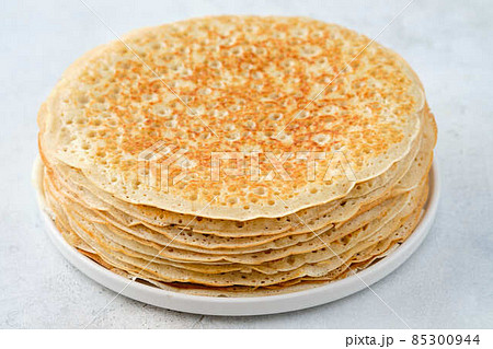 Crepes, thin pancakes with honey and butter on a white plate. Close up. 85300944
