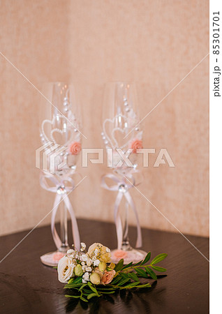 Champagne glasses and groom's boutonniere on brown background Champagne glasses and groom's boutonniere on brown background 85301701