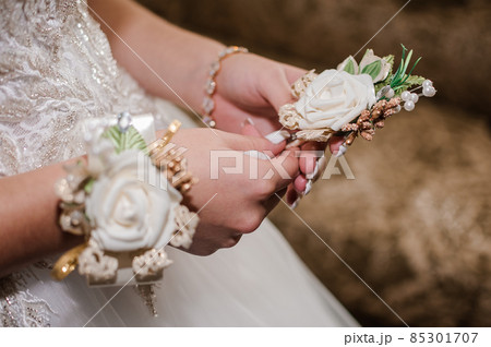 Boutonniere of the groom with white flowers in the hands of the bride 85301707