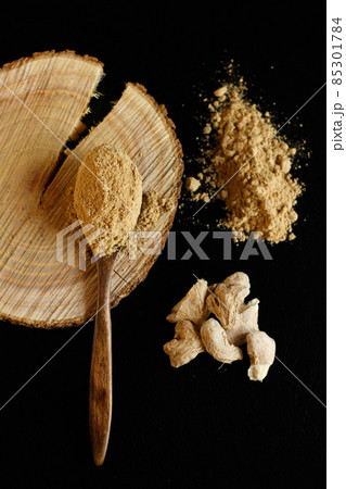 Organic seasoning powder of ginger with root on wooden plate 85301784
