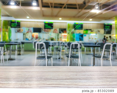 Wooden table top on blurred food court Wooden table top on blurred food court 85302089
