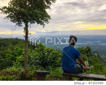 The man relax at mountain with sunshine and color of cloud sky The man relax at mountain with sunshine and color of cloud sky 85302090