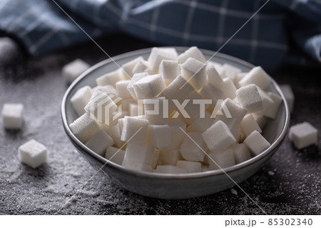 White sugar cubes in a blue bowl on the table White sugar cubes in a blue bowl on the table 85302340