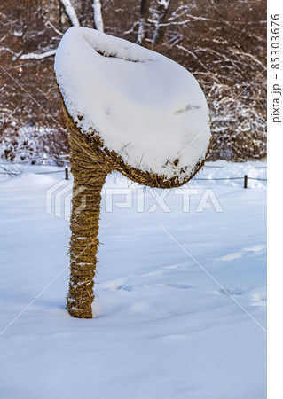 Garden installation in the form of a mushroom made of straw in the snow 85303676