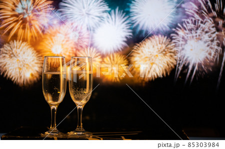 two champagne glasses against fireworks New Year's eve celebration two champagne glasses against fireworks New Year's eve celebration 85303984