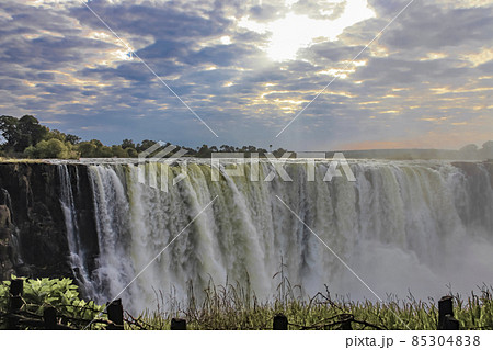 Beautiful cloudy landscape with morning sun rays over Victoria Falls. 85304838