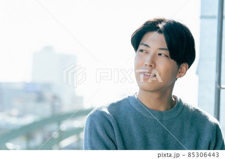 窓辺でリラックスする若い男性 窓辺でリラックスする若い男性 85306443