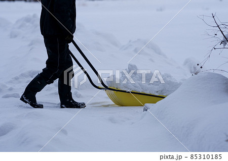 雪かきをする人物の足元 85310185