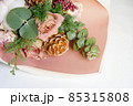 淡いピンク色のバラの花と松かさ飾りの花束 85315808