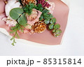 淡いピンク色のバラの花と松かさ飾りの花束 85315814