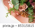 淡いピンク色のバラの花と松かさ飾りの花束 85315815