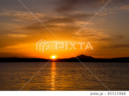 涸沼の夕景。筑波山の麓に太陽が沈もうしている、その周囲に大きな傘の様にオレンジ色の雲が面白く綺麗だ。 85315988