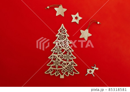 wooden decorative decoration of fir-tree, star and deer on red background wooden decorative decoration of fir-tree, star and deer on red background 85318581