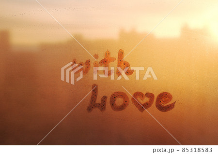 Hand drawn text With love on muddy glass wet orange window in city on sunset 85318583