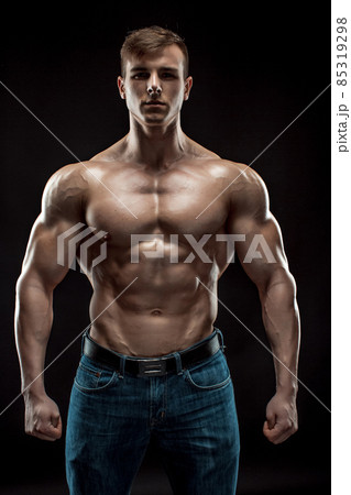 Muscular bodybuilder guy doing posing over black background 85319298