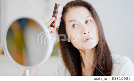 髪にブラシをかけるシニア女性 髪にブラシをかけるシニア女性 85319989