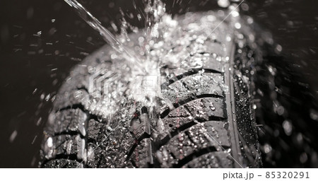 Water splashing on new car tyre closeup 85320291