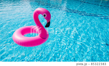 Flamingo plastic. Pink inflatable flamingo in pool water for beach background. Trendy summer concept. Flamingo plastic. Pink inflatable flamingo in pool water for beach background. Trendy summer concept. 85322383