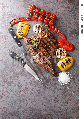 Beef T-Bone steak with grilled vegetables and seasoning on grey background. Vertical top view 85322418