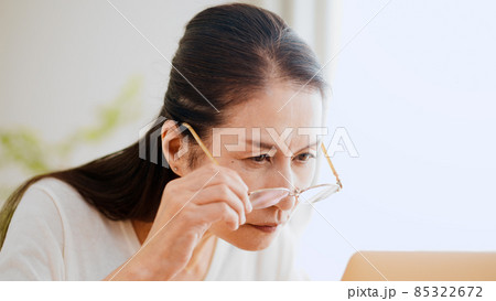 老眼鏡でノートパソコンを覗くシニア女性 85322672