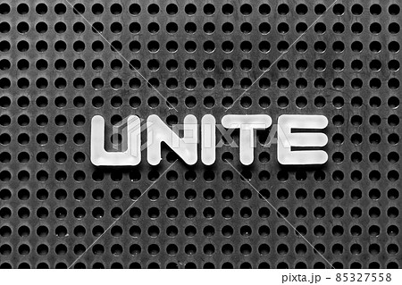White alphabet letter in word unite on black pegboard background 85327558
