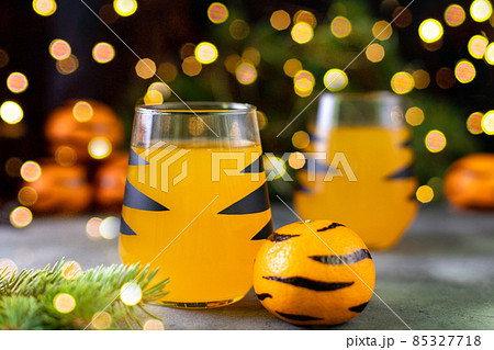 orange mandarin cocktail in glass with black stripes. Christmas holiday welcome drink. Concept for children new year 85327718