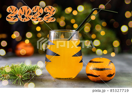 orange mandarin cocktail in glass with black stripes. Christmas holiday welcome drink. Concept for children new year 85327719
