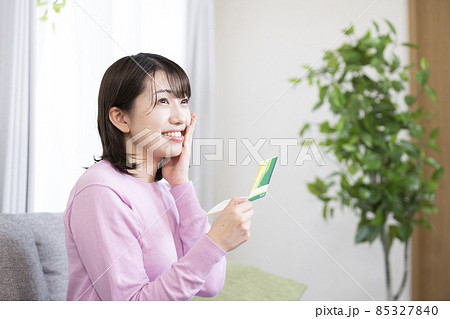 預金通帳を見て喜ぶ女性 85327840