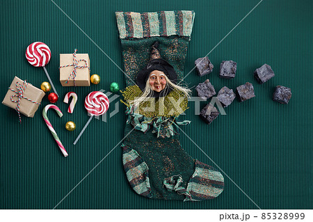 Befana sock with sweet coal and candy on dark greeen background. Italian Epiphany day tradition. Befana sock with sweet coal and candy on dark greeen background. Italian Epiphany day tradition. 85328999