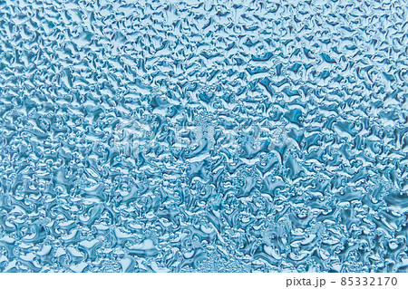 Cold blue water drops on glass window texture, winter background Cold blue water drops on glass window texture, winter background 85332170
