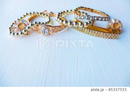 a lot of gold costume jewelry with different materials on a white background. Copy space a lot of gold costume jewelry with different materials on a white background. Copy space 85337555