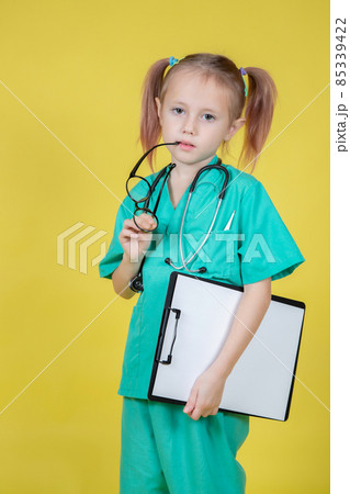 Portrait of serious little kid dressed in doctors coat with a tablet in hand Portrait of serious little kid dressed in doctors coat with a tablet in hand 85339422