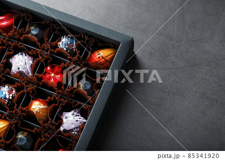 Handmade chocolates in a box on a dark background. 85341920