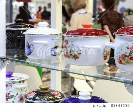 Enamelled kitchen utensils, household goods, tableware department. Many pots in a shop window on the shelves 85343550