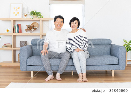 リビングでソファに座るシニアカップルのポートレート 85346660