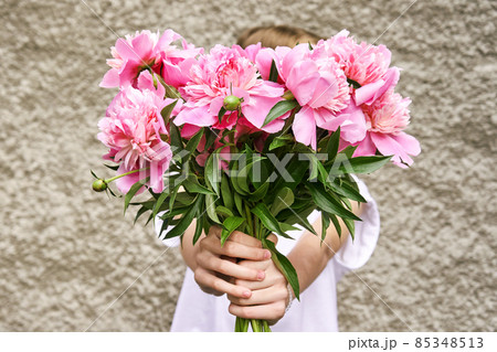 Peony pink bouquet. Female people holding flowers. Faceless lifestyle concept Peony pink bouquet. Female people holding flowers. Faceless lifestyle concept 85348513