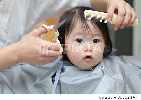 ママに前髪を切って貰う赤ちゃんの女の子 85352147