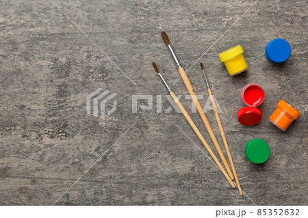 art palette with paint and brushes, close up. Top view with empty space. workplace for creativity. home teaching concept drawing 85352632