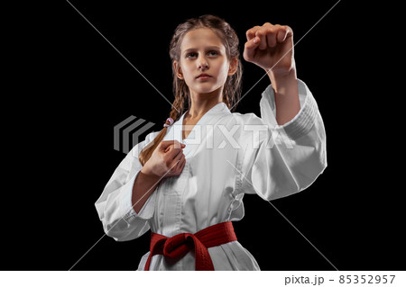 One young girl, teen, taekwondo athlete posing isolated over dark background. Concept of sport, education, skills 85352957