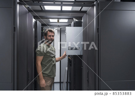 IT engineer working In the server room or data center The technician puts in a rack a new server of corporate business mainframe supercomputer or cryptocurrency mining farm. IT engineer working In the server room or data center The technician puts in a rack a new server of corporate business mainframe supercomputer or cryptocurrency mining farm. 85353883