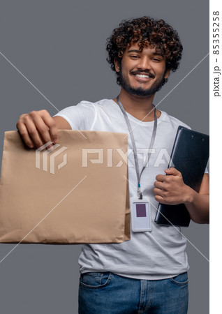 Male with a package and documents posing for the camera 85355258