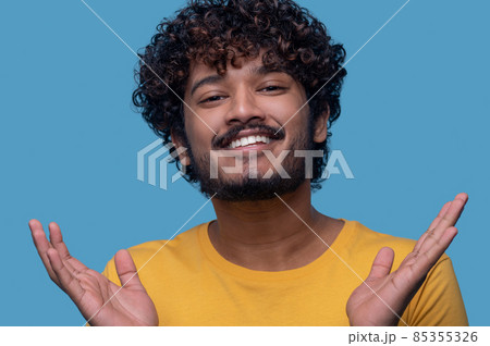 Man with palms up smiling at the camera Man with palms up smiling at the camera 85355326
