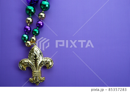 Frame of green, gold, and purple Mardi Gras beads with Fleur de lis Frame of green, gold, and purple Mardi Gras beads with Fleur de lis 85357283