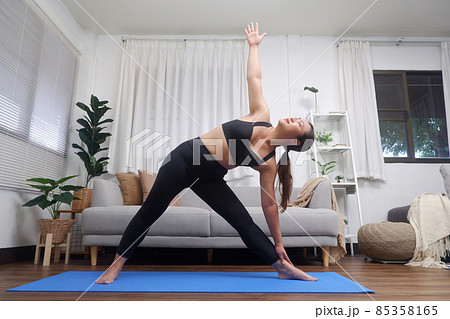 Young Asian women practicing yoga, exercise, stretching in the living room. 85358165