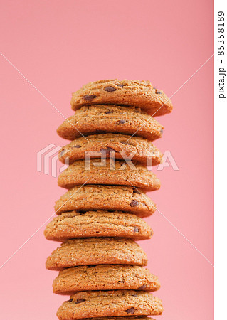 Oatmeal cookies with pieces of chocolate stand like a tower on a pink background 85358189