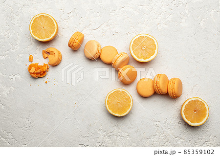 Orange French Macaroons with orange fruit filling on a creamy white clay background 85359102